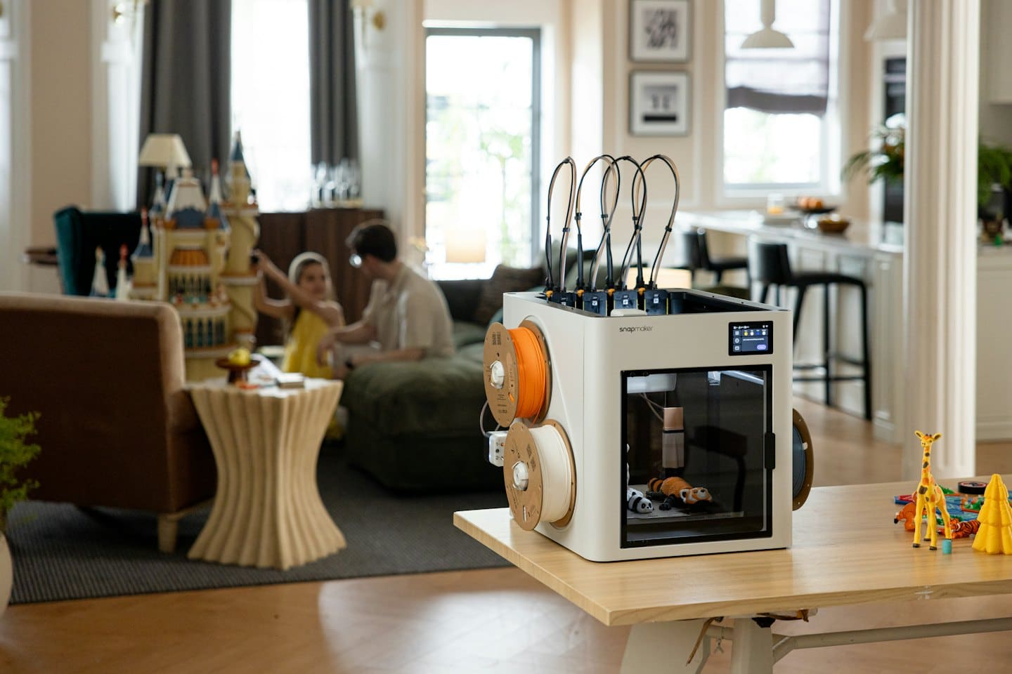 3D printer creating toys on a wooden table.